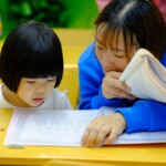 teacher guides student with reading
